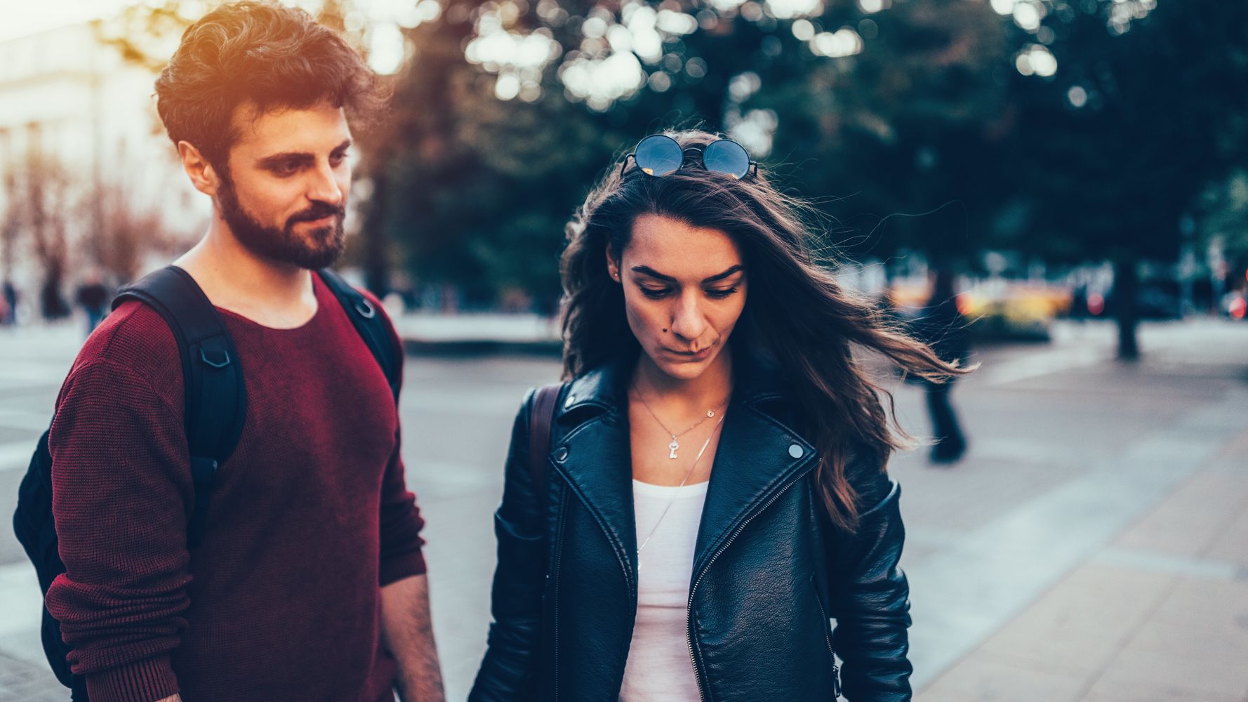 Two people outdoors, with one looking down.